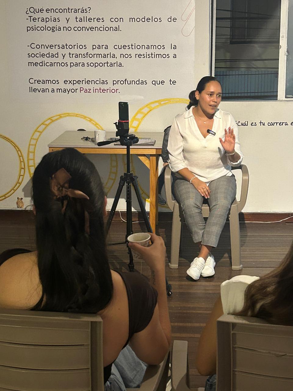Facilitadora dirigiendo un taller con micrófono frente al grupo